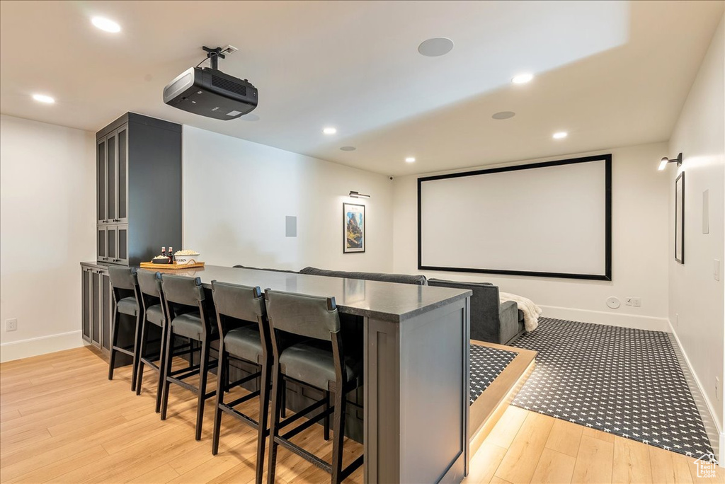 Cinema with baseboards, light wood-style flooring, a bar, and recessed lighting