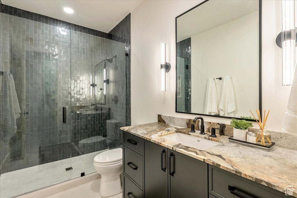 Bathroom with toilet, vanity, a stall shower, and recessed lighting