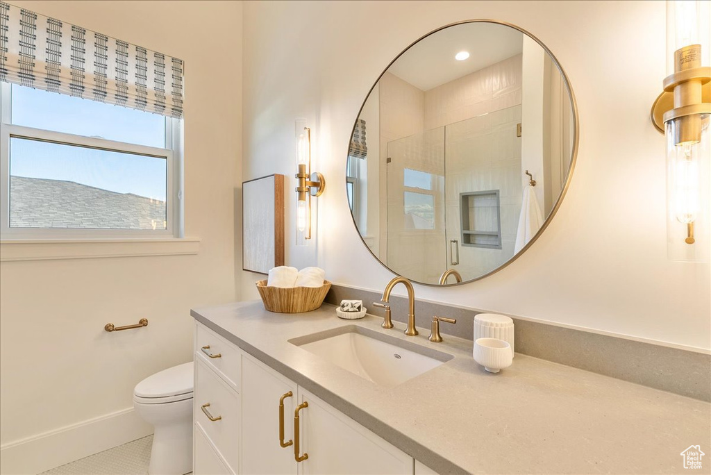 Bathroom featuring vanity, toilet, a shower with door, tile patterned floors, and baseboards