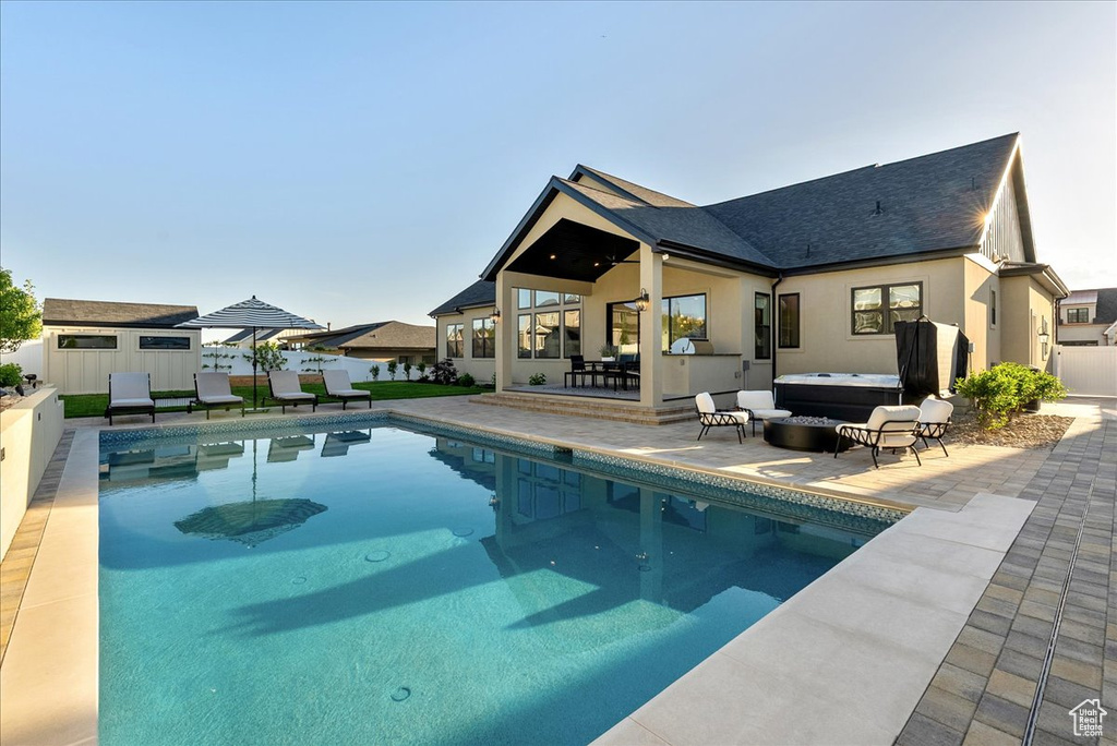 View of pool with an outdoor hot tub and a patio area