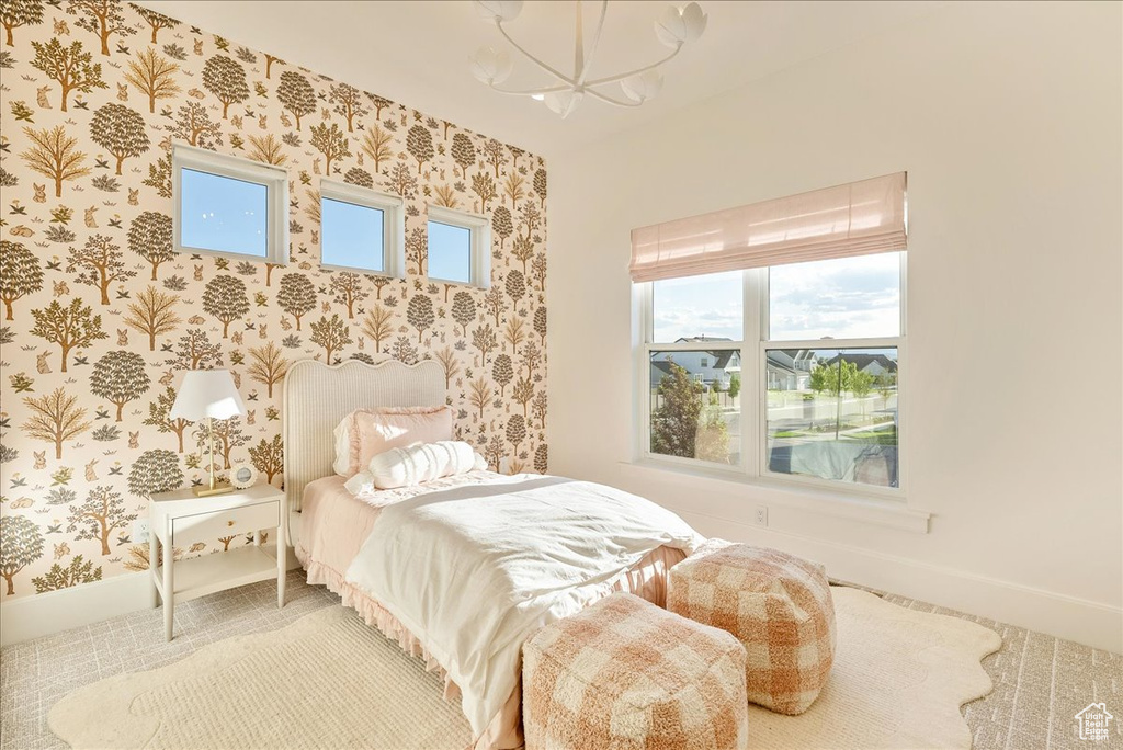 Bedroom with a chandelier, wallpapered walls, and baseboards