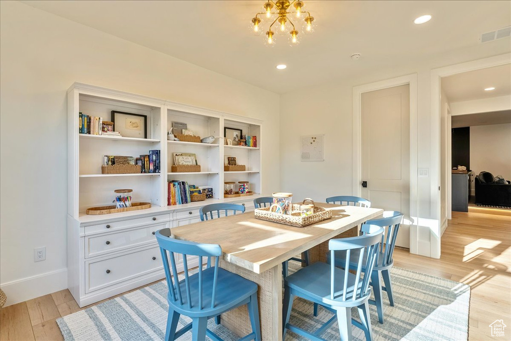 Dining space featuring a chandelier, light wood-style flooring, baseboards, and recessed lighting