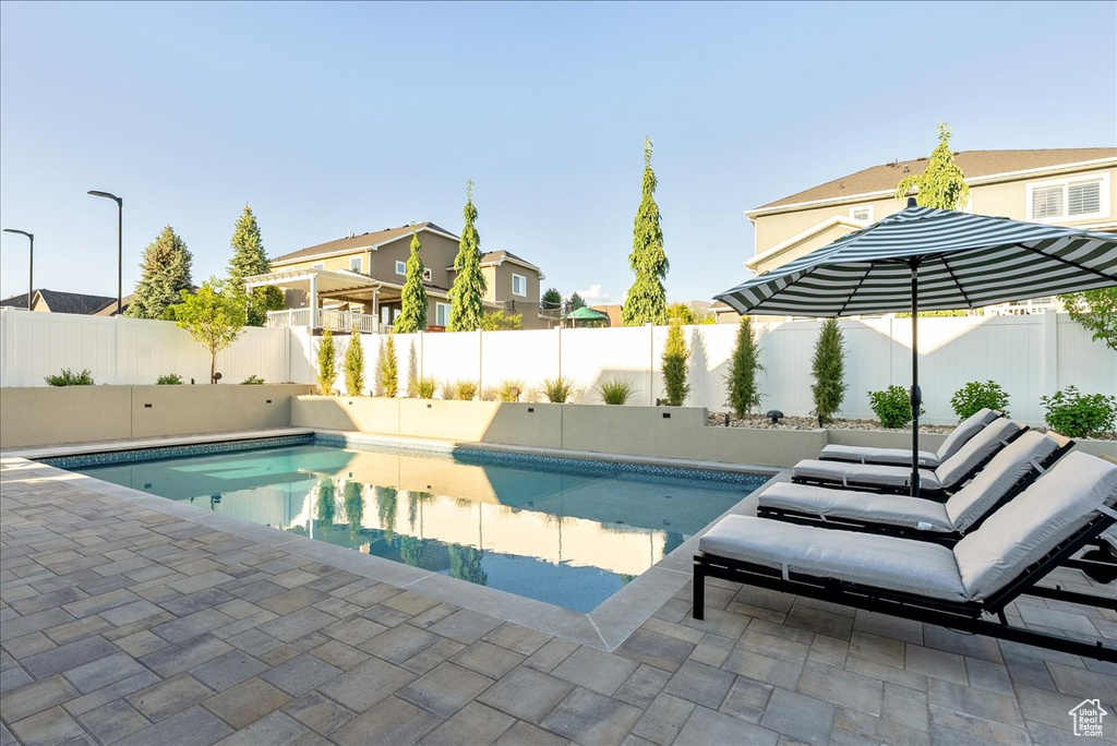 View of pool featuring a fenced backyard, a patio area, and a residential view