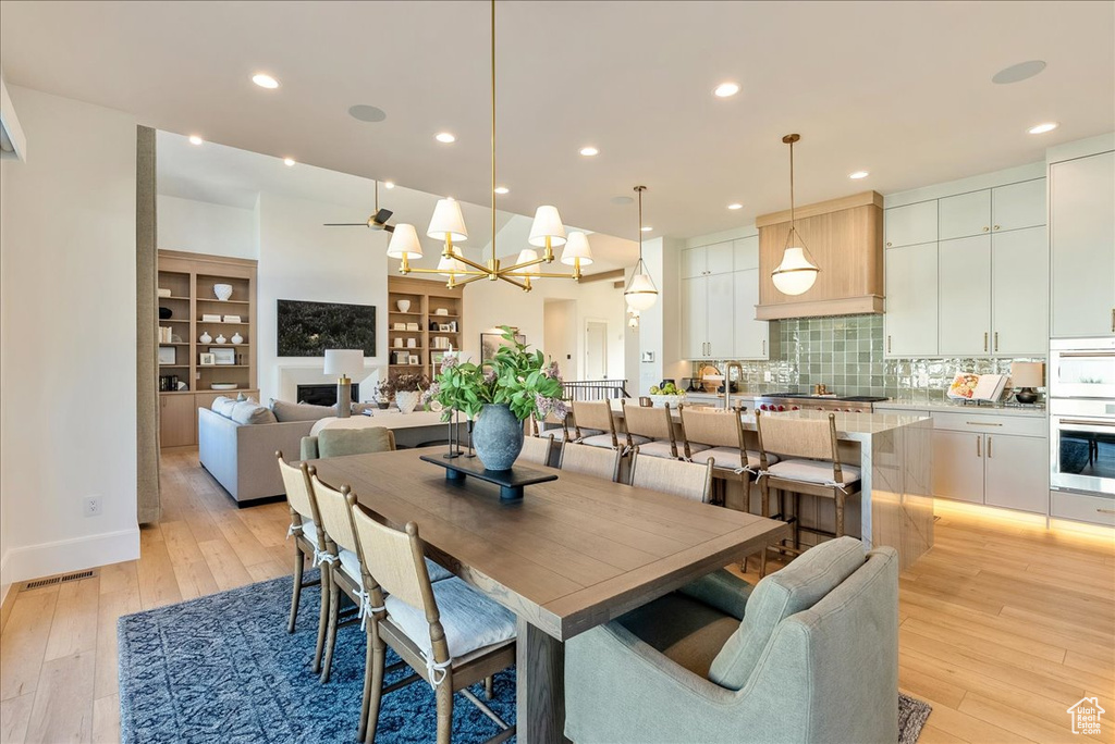 Dining area with light wood-type flooring, recessed lighting, and a chandelier