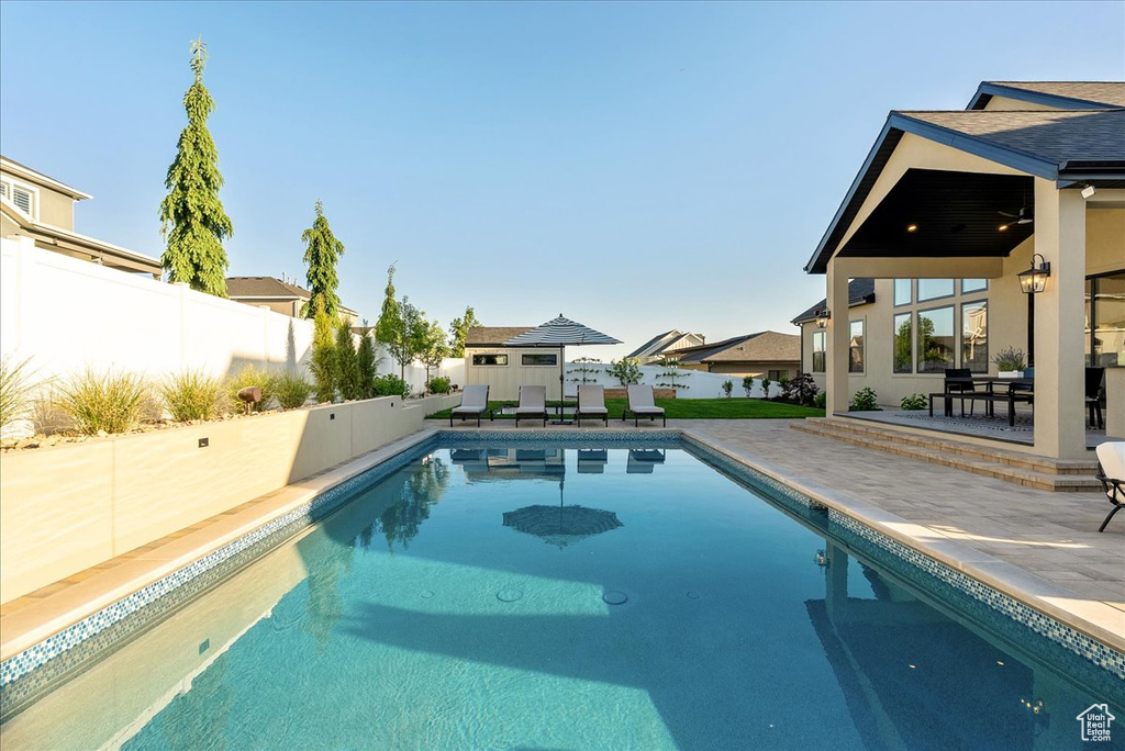 View of swimming pool featuring a patio area, a fenced backyard, and a residential view