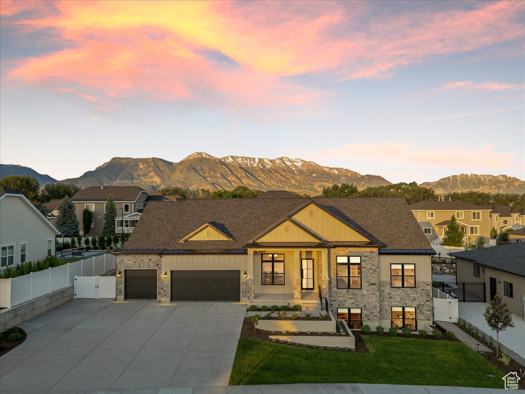 View of front of property featuring stone siding, a gate, a mountain view, and a garage