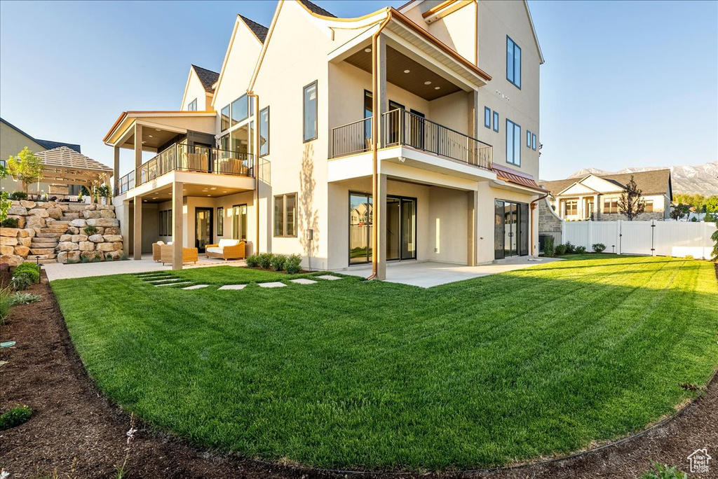 Back of house featuring a balcony, stucco siding, and a patio area