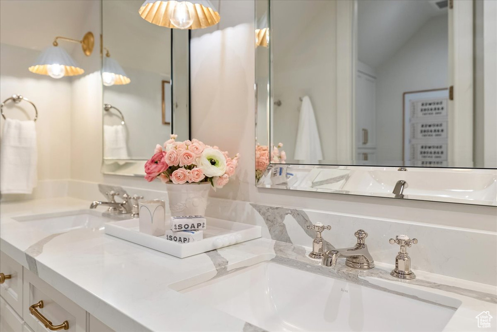 Bathroom featuring double vanity and vaulted ceiling