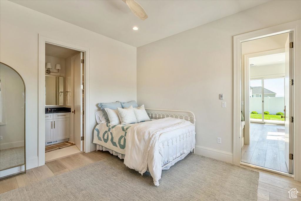 Bedroom with light wood-style flooring, baseboards, recessed lighting, and ensuite bathroom
