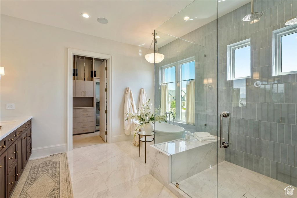 Full bathroom with a tile shower, vanity, a garden tub, plenty of natural light, and recessed lighting