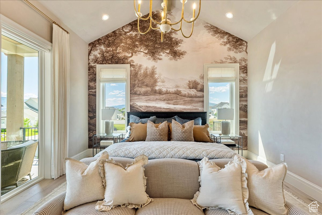 Bedroom with vaulted ceiling, a chandelier, baseboards, wood finished floors, and wallpapered walls