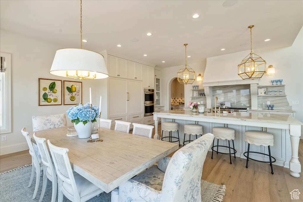Dining area featuring light wood-style flooring, a chandelier, recessed lighting, and baseboards