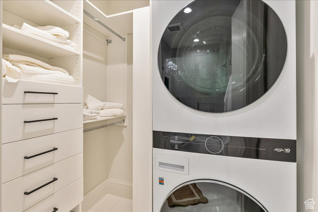 Washroom featuring estacked washer and dryer, baseboards, and tile patterned floors