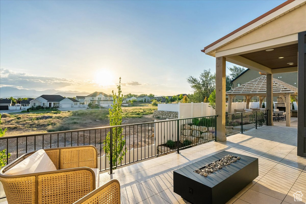 Wooden terrace featuring an outdoor living space with a fire pit, a patio area, and a gazebo