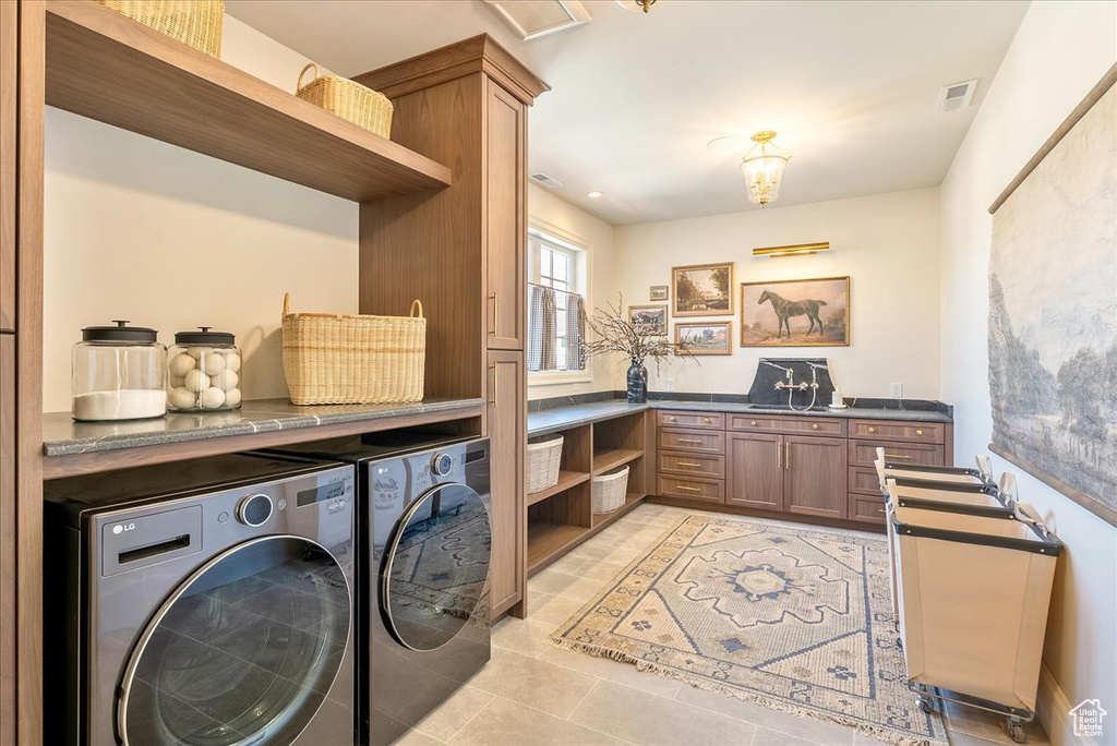 Laundry room featuring washing machine and clothes dryer and light tile patterned flooring