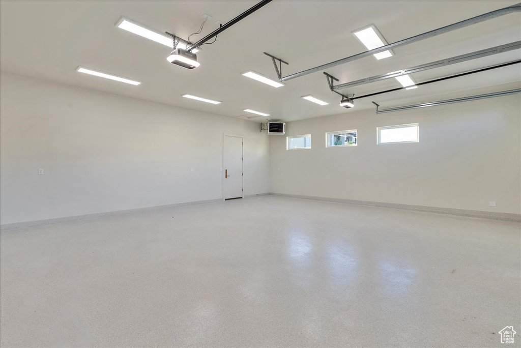 Garage with a garage door opener and baseboards