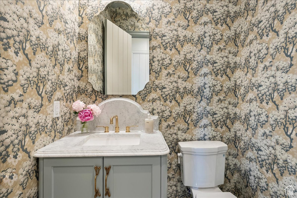 Half bathroom featuring vanity and toilet