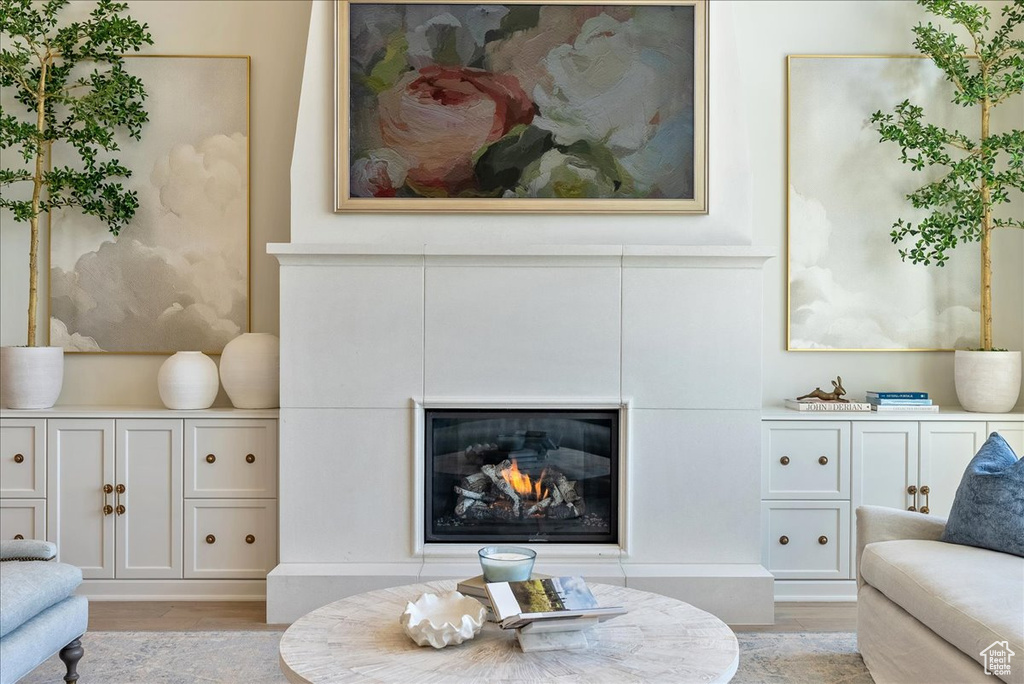 Living room with light wood-style flooring and a glass covered fireplace