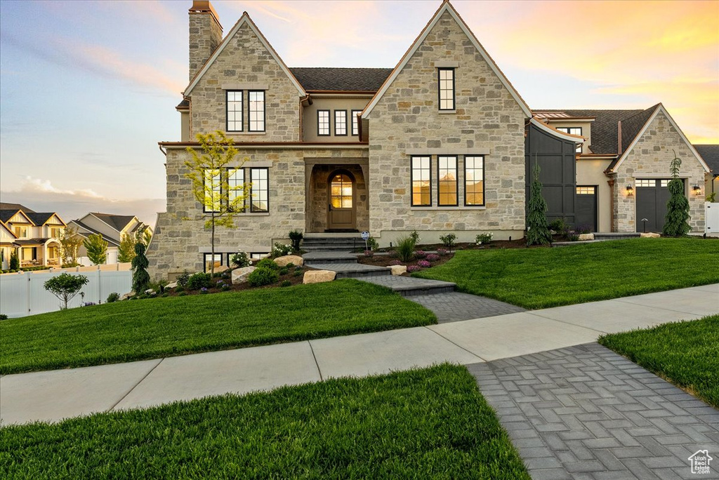 View of front of home featuring stone siding, stucco siding, and a chimney