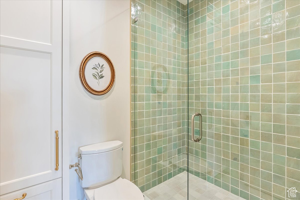 Bathroom with a shower stall and toilet
