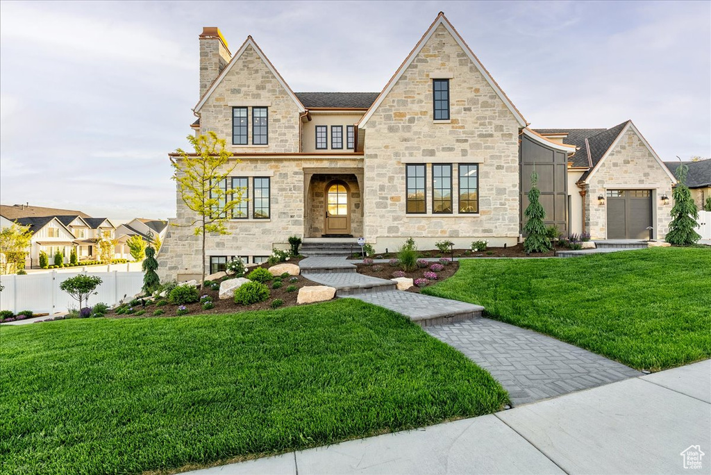 View of front of house featuring stone siding and a chimney