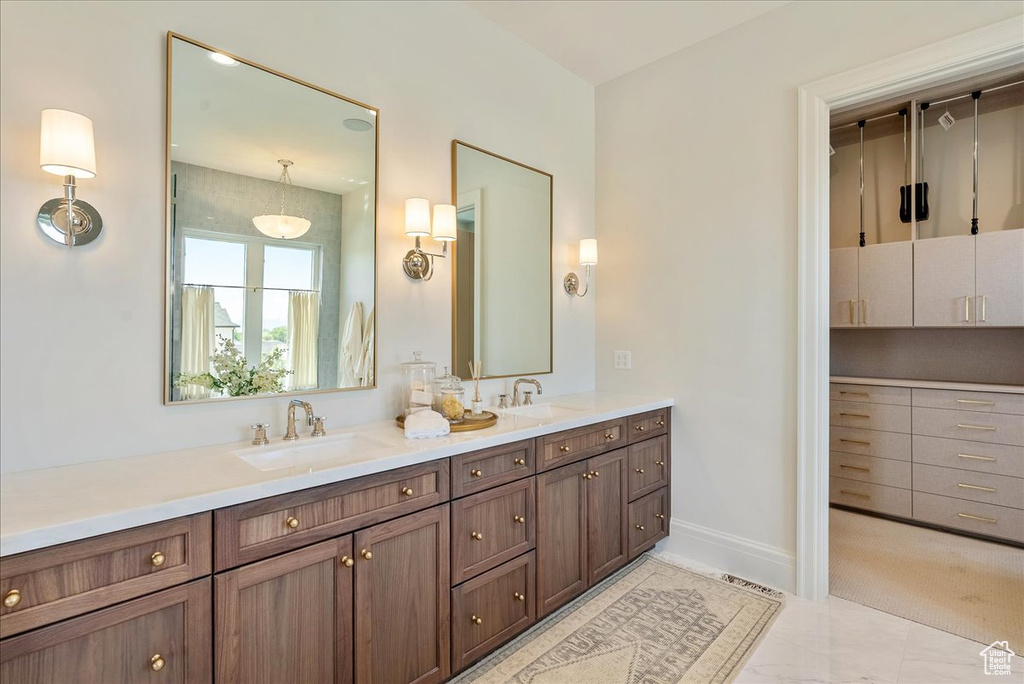 Full bath featuring double vanity and baseboards