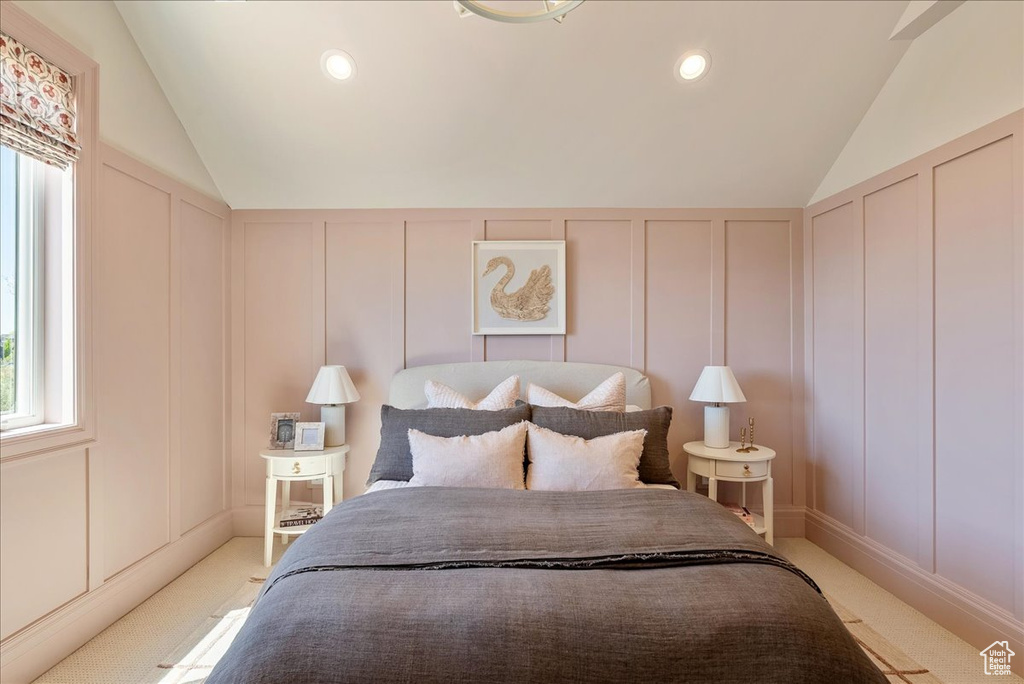 Bedroom featuring a decorative wall, lofted ceiling, light carpet, and recessed lighting