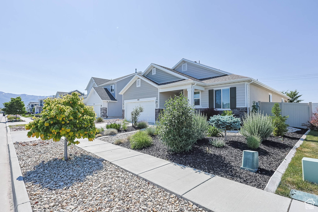 View of front of house featuring a garage and stone siding