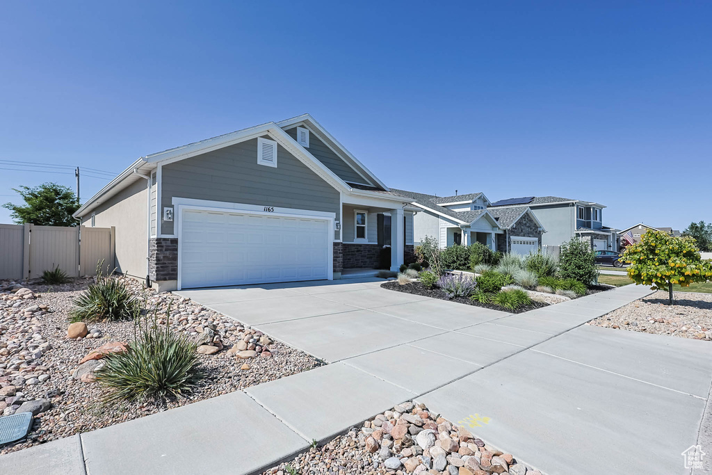 View of front facade featuring a garage and driveway
