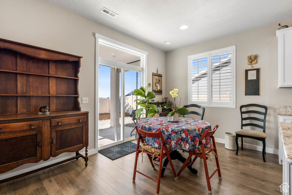 Dining area with wood finished floors, baseboards, and recessed lighting