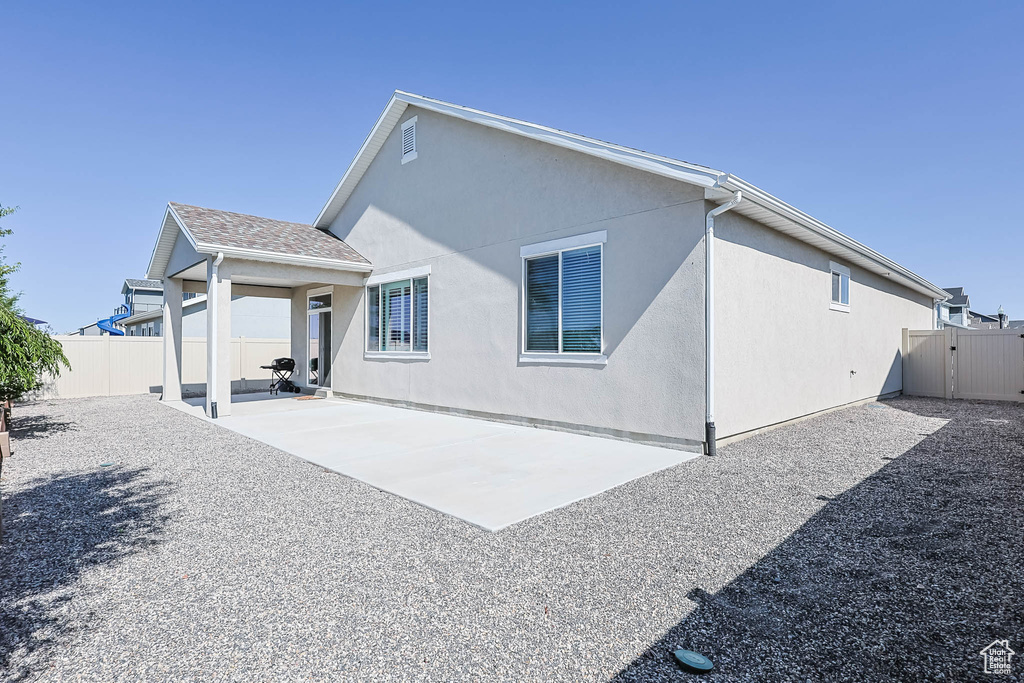 Back of property with a patio and stucco siding