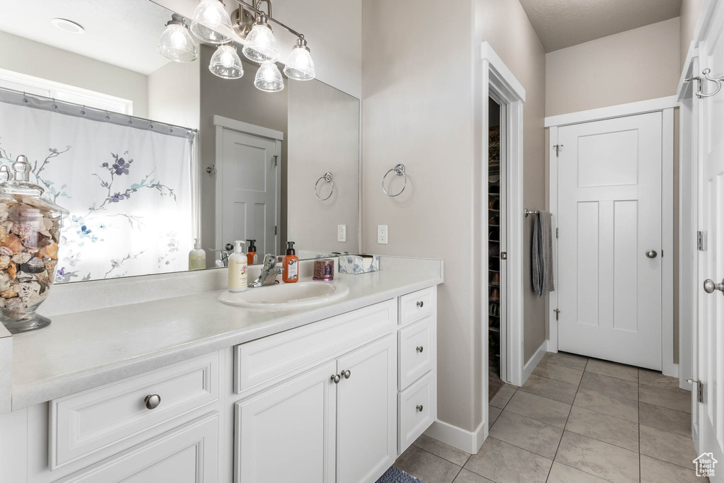 Bathroom with vanity, tile patterned flooring, a closet, and baseboards