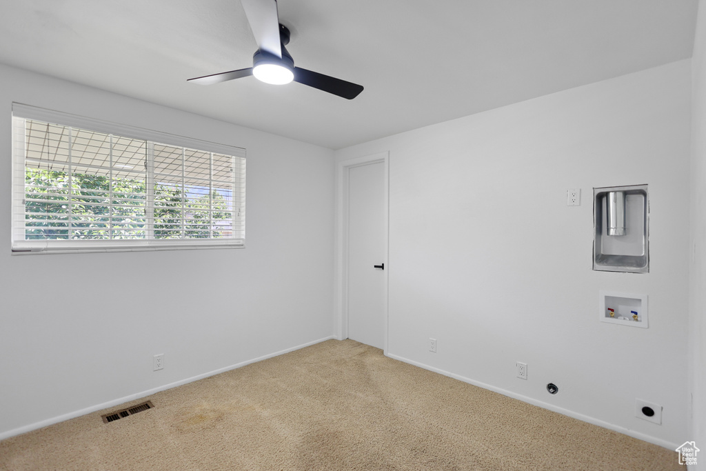 Spare room featuring light carpet, a ceiling fan, and baseboards