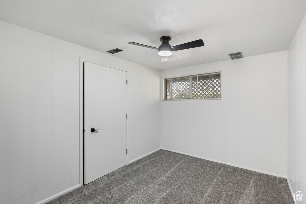 Unfurnished bedroom featuring dark colored carpet, ceiling fan, baseboards, and a closet