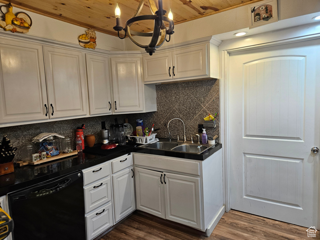Kitchen with black dishwasher, a sink, a chandelier, white cabinets, and wood ceiling
