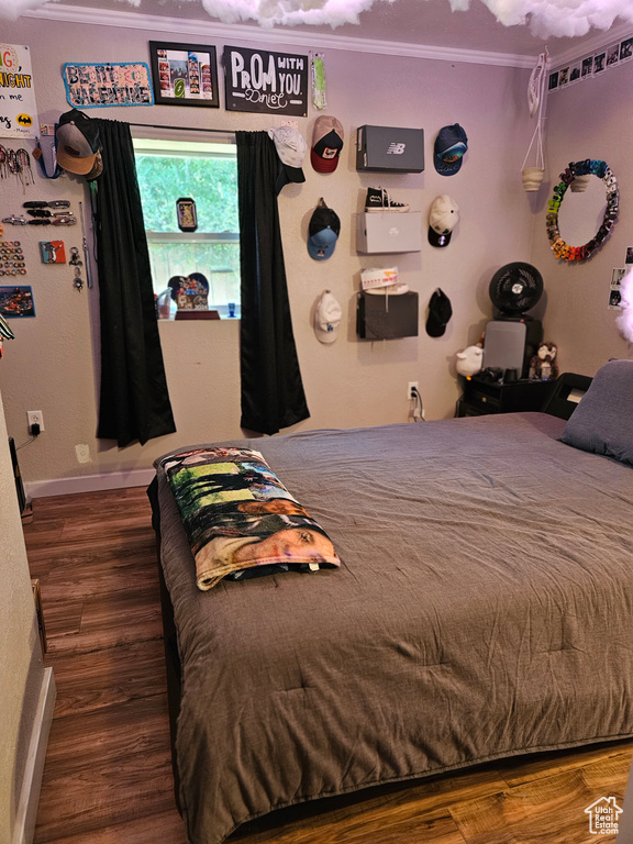 Bedroom featuring crown molding, wood finished floors, and baseboards