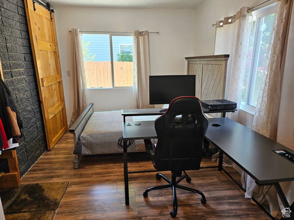Home office with wood finished floors and a barn door