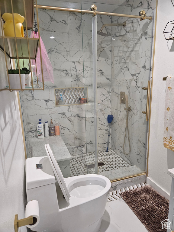 Full bath featuring toilet and a marble finish shower