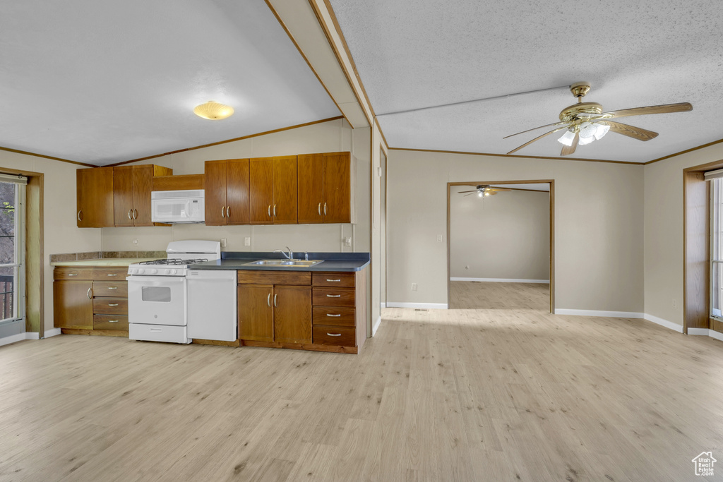 Kitchen with white appliances, brown cabinetry, a ceiling fan, light wood-style flooring, and lofted ceiling
