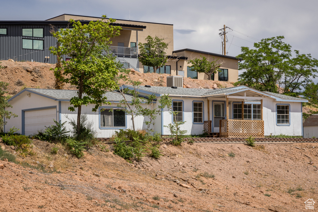 View of front facade featuring central AC unit and a garage