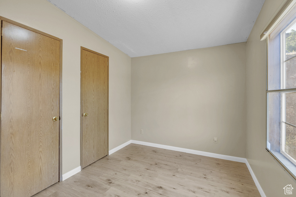 Unfurnished bedroom featuring light wood finished floors and baseboards