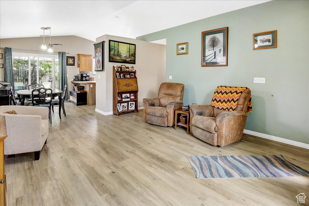 Living area with light wood-style floors, baseboards, and lofted ceiling