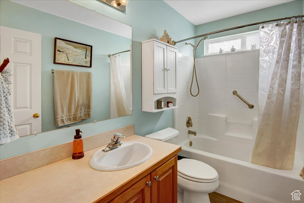 Full bath featuring vanity, shower / tub combo, and toilet