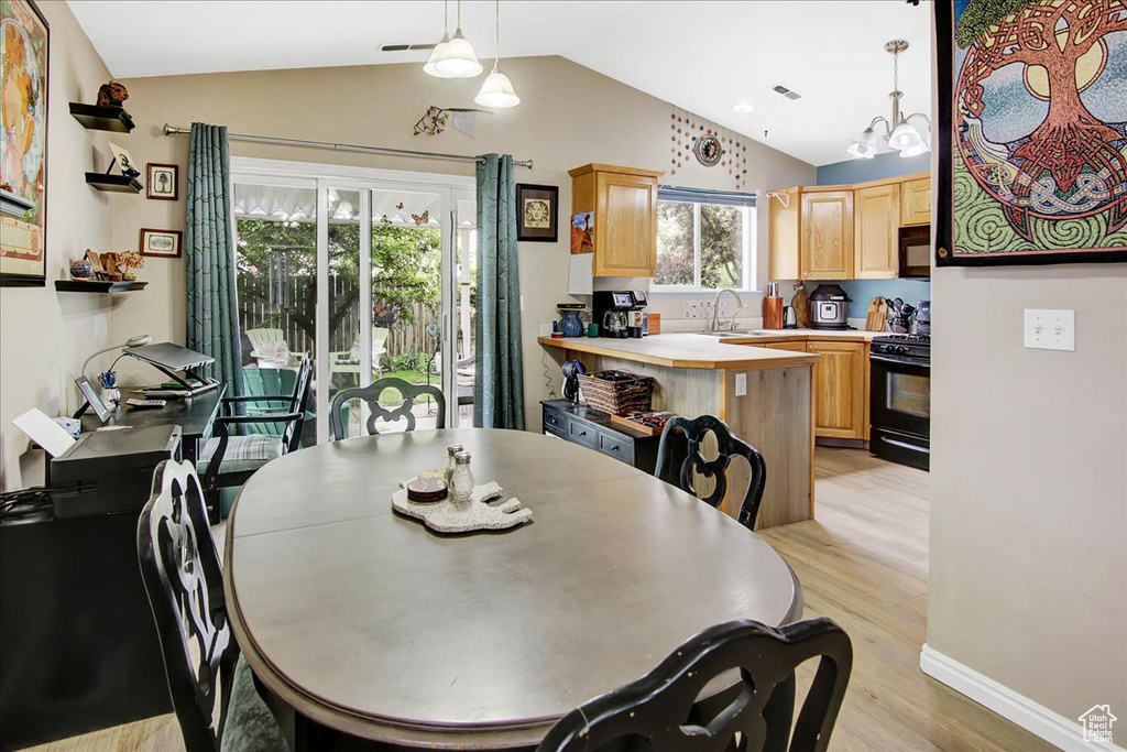 Dining space featuring light wood-style floors and lofted ceiling