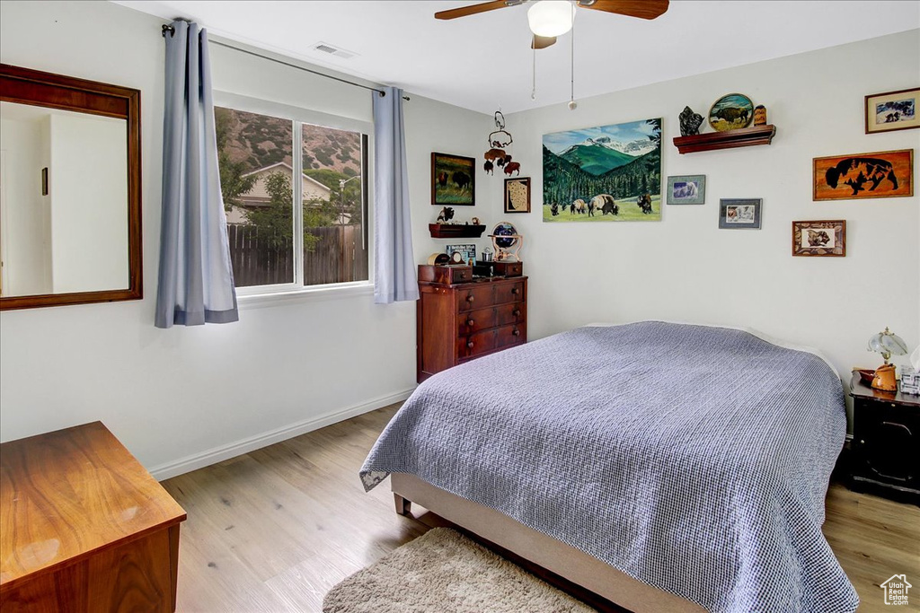 Bedroom with wood finished floors, baseboards, and ceiling fan