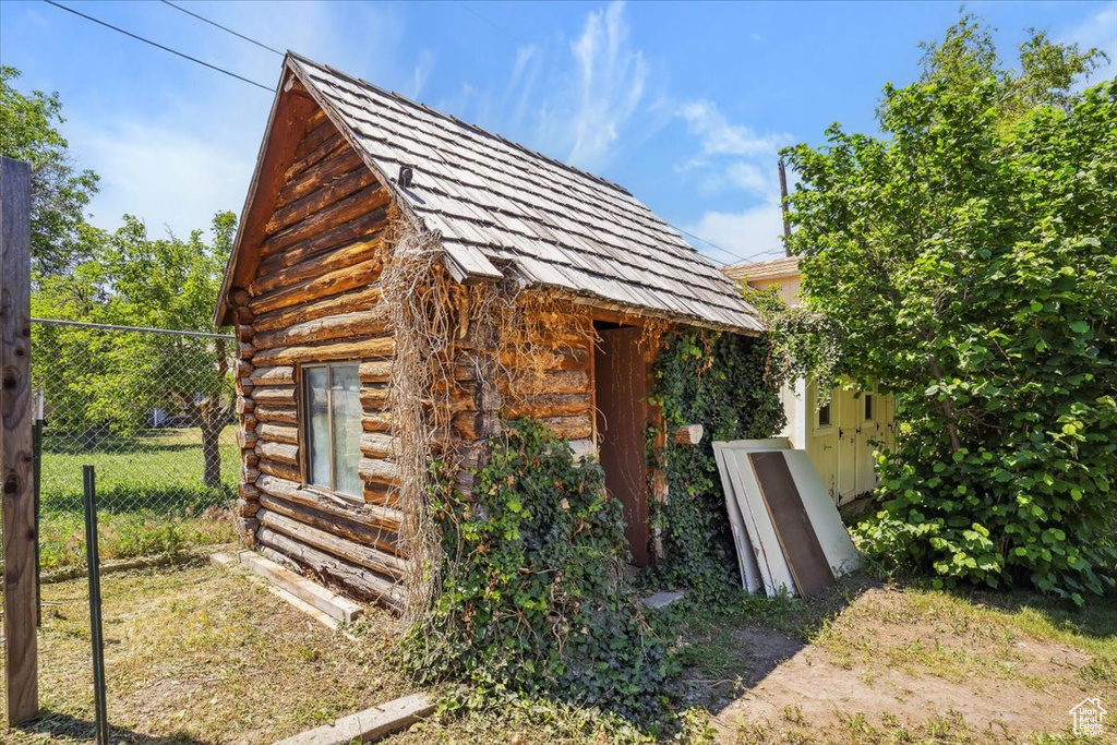 View of side of home with an outbuilding and log siding