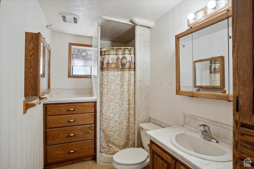 Full bath with vanity, toilet, and a shower with shower curtain