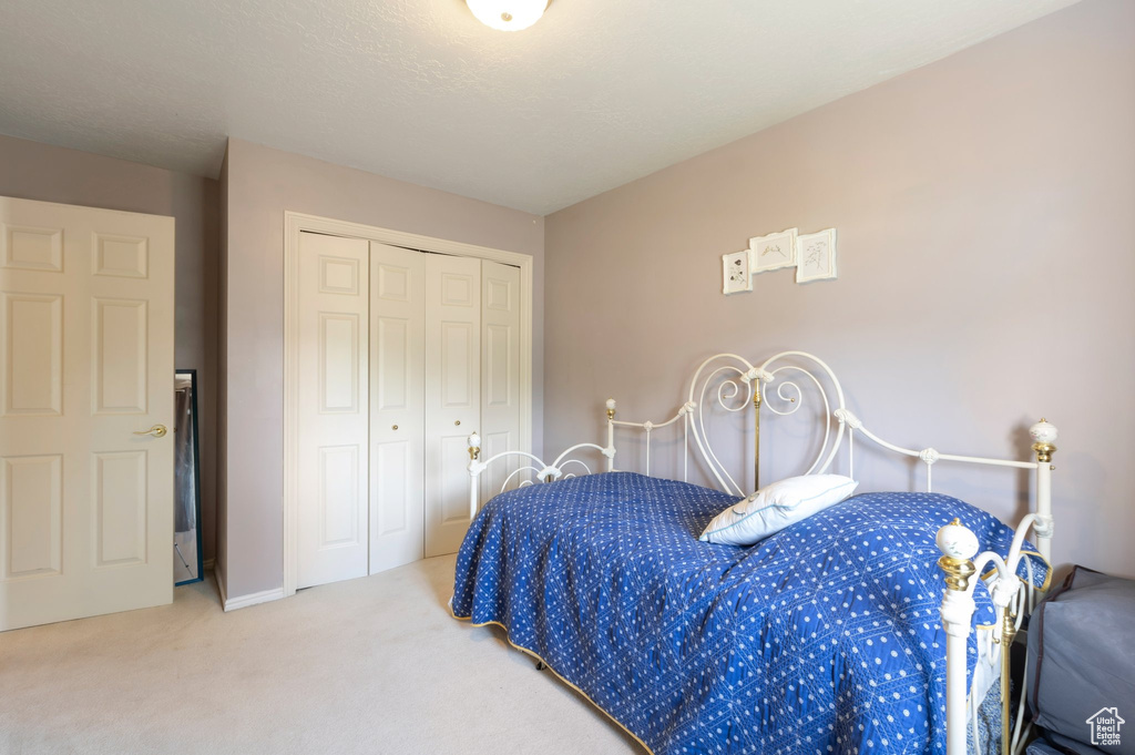 Bedroom featuring carpet flooring and a closet