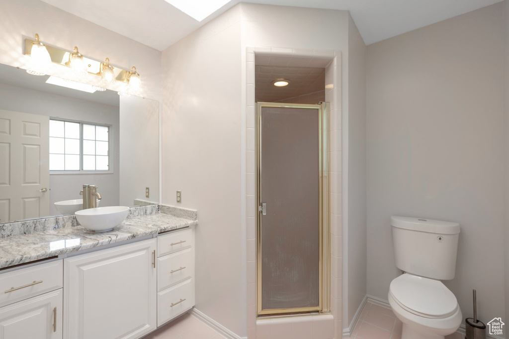 Full bath with vanity, a stall shower, baseboards, toilet, and tile patterned floors