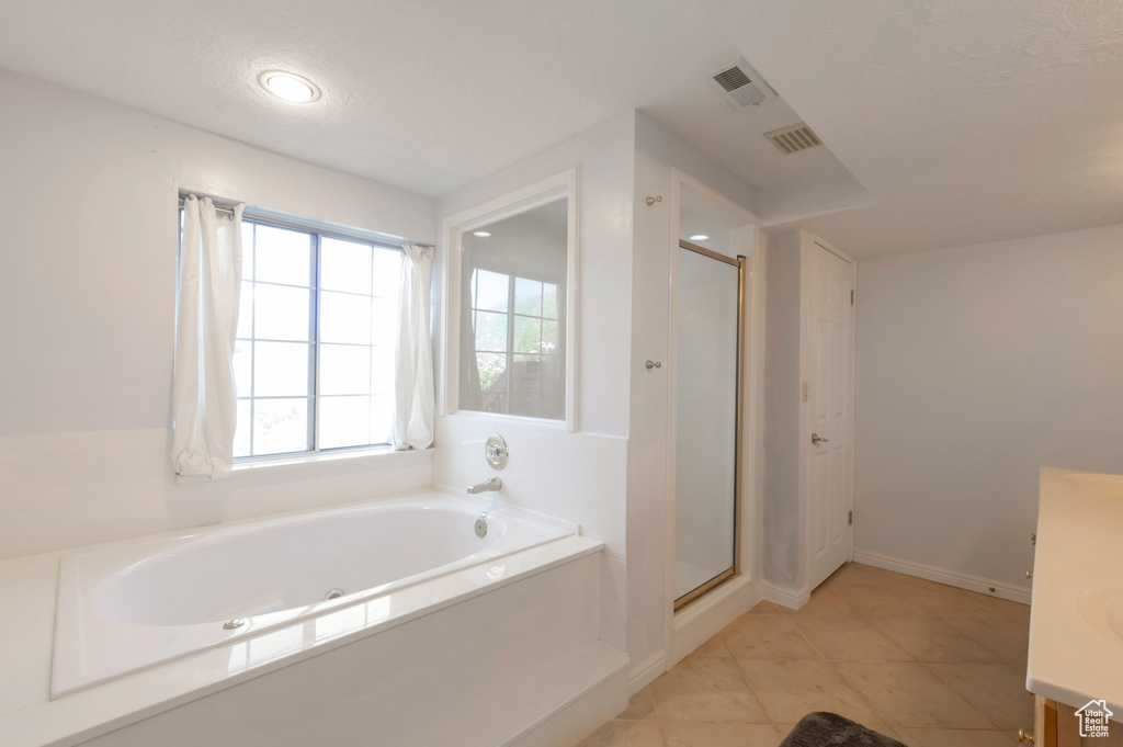 Bathroom with vanity, a bath, a shower stall, tile patterned floors, and recessed lighting